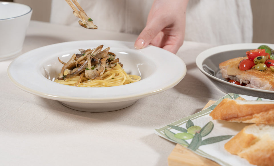 きのこのパスタを白いうつわに盛り付ける手元